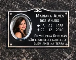 Placa de túmulo preta com foto oval em moldura prateada, nome, datas e frase